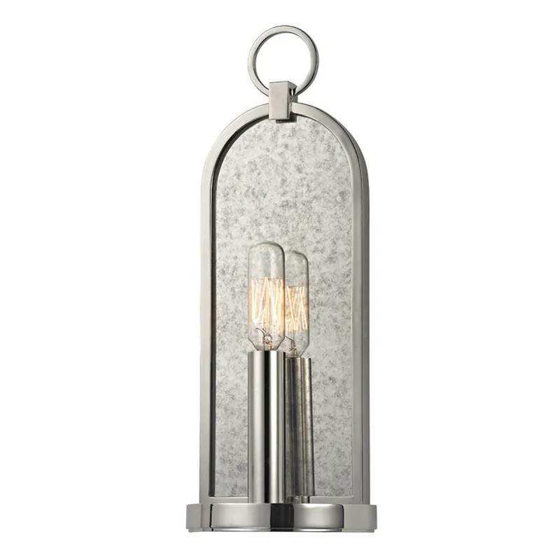 A clean, classic arch, fitted with a cast ring at the apex, provides a handsome frame for the mottled haze of Lowell’s smokey mirror backplate. The clean lines of its metal candlestick provide contemporary contrast to its antique inspiration, while a tungsten filament bulb reflects with quiet drama.   Amethyst Home provides interior design, new home construction design consulting, vintage area rugs, and lighting in the Houston metro area.