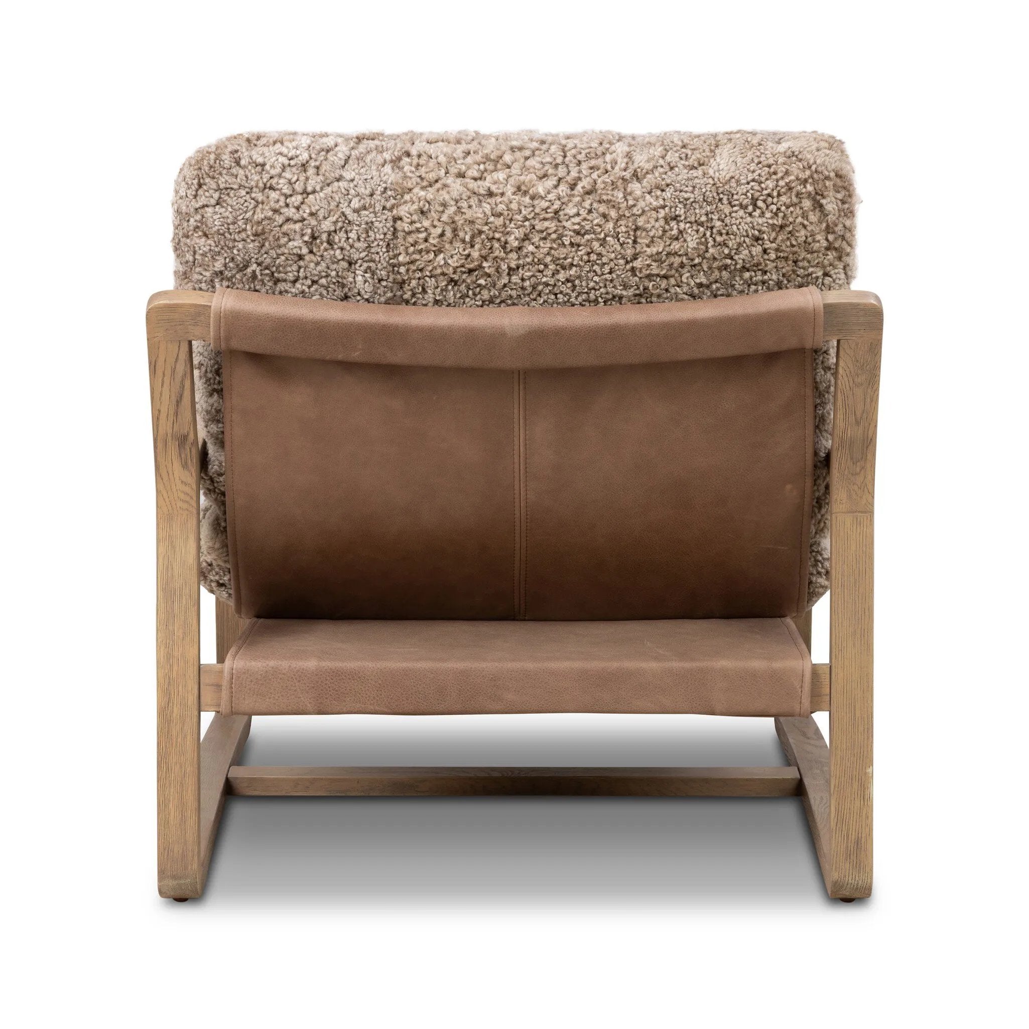 The perfect place to curl up with a good book. A hand-shaped parawood frame supports low, deep seating upholstered with taupe shearling Amethyst Home provides interior design, new home construction design consulting, vintage area rugs, and lighting in the Des Moines metro area.