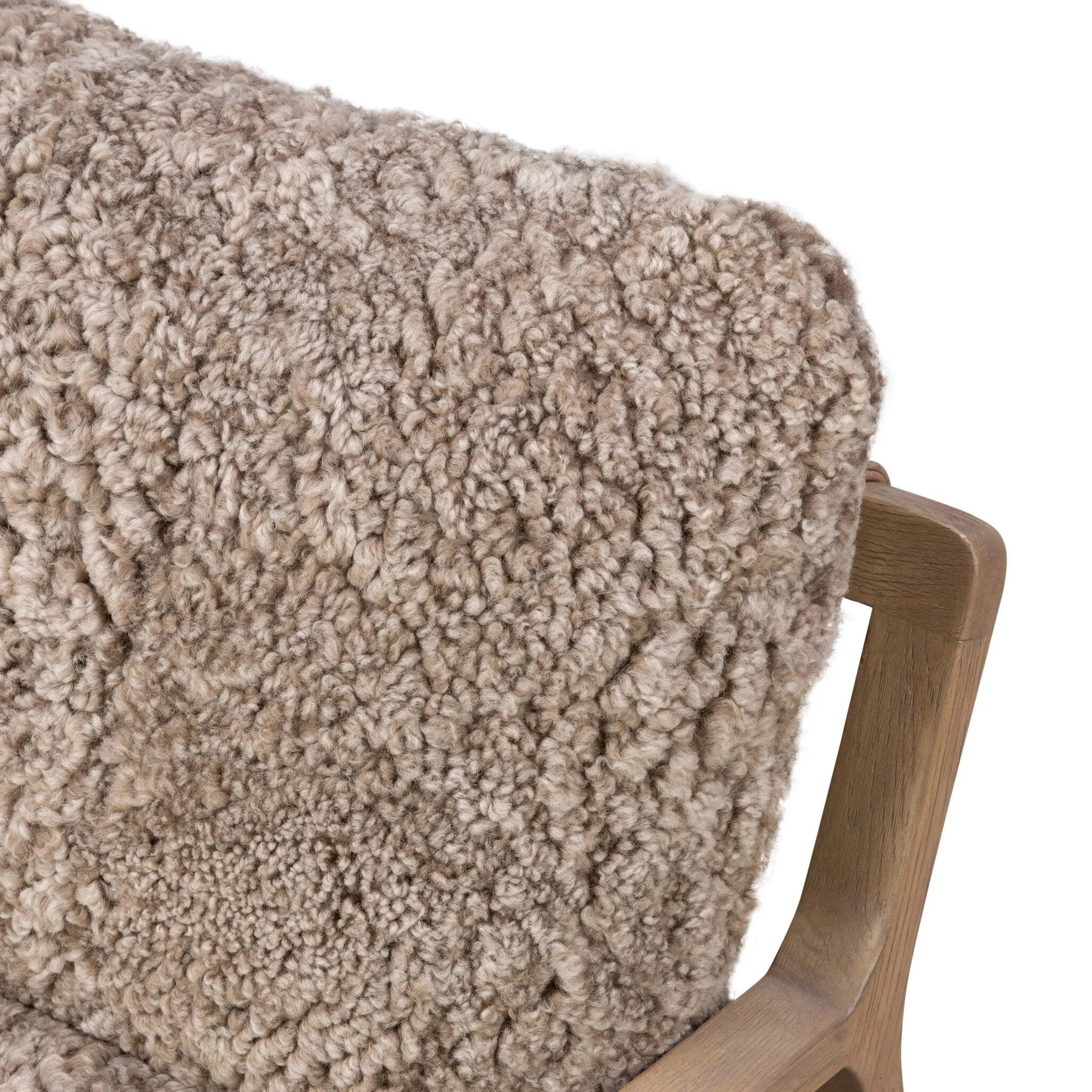 The perfect place to curl up with a good book. A hand-shaped parawood frame supports low, deep seating upholstered with taupe shearling Amethyst Home provides interior design, new home construction design consulting, vintage area rugs, and lighting in the Omaha metro area.