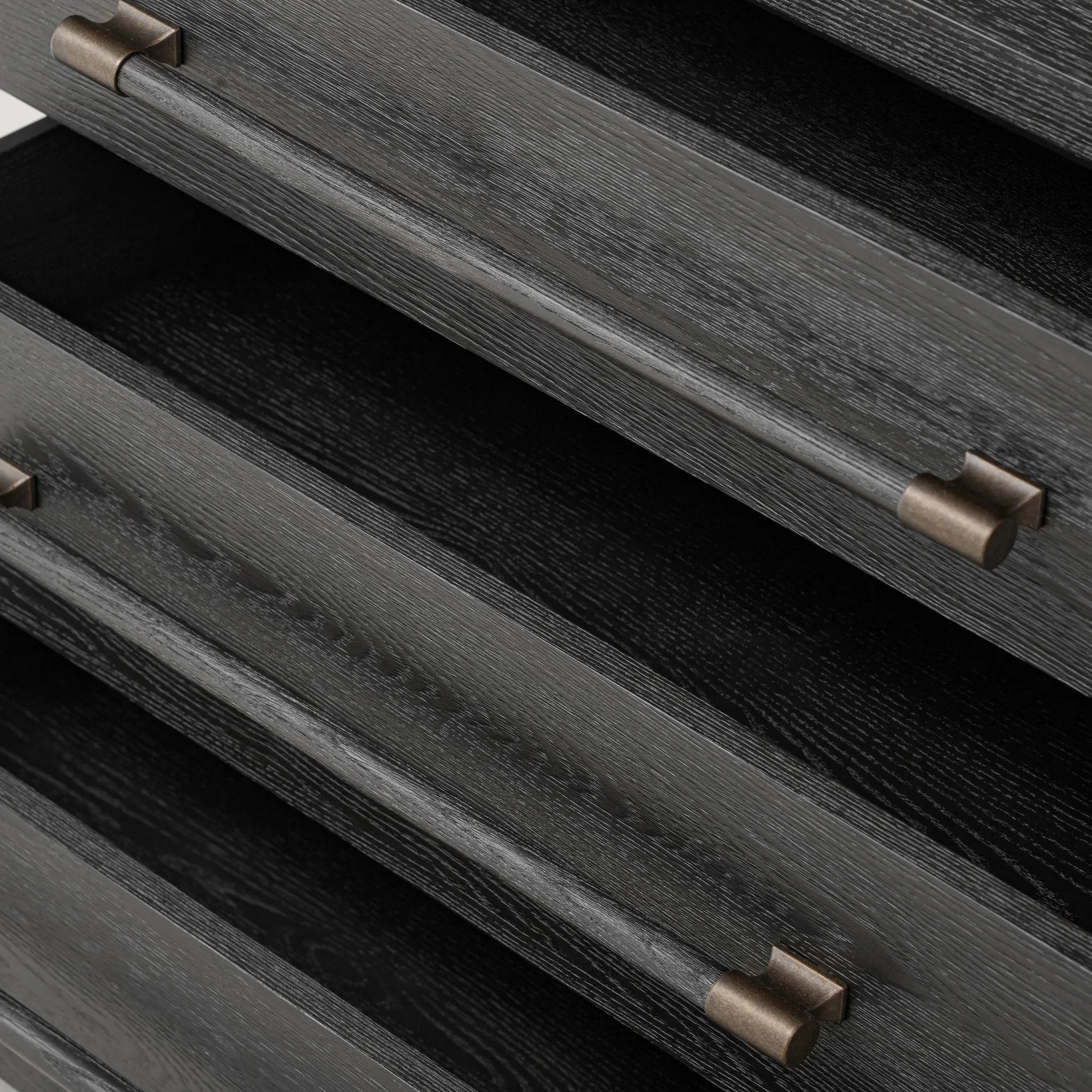 Beautifully minimalist. A three-drawer dresser made from black-finished ash  features long, linear bronzed hardware for a smooth, clean look Amethyst Home provides interior design, new home construction design consulting, vintage area rugs, and lighting in the Dallas metro area.