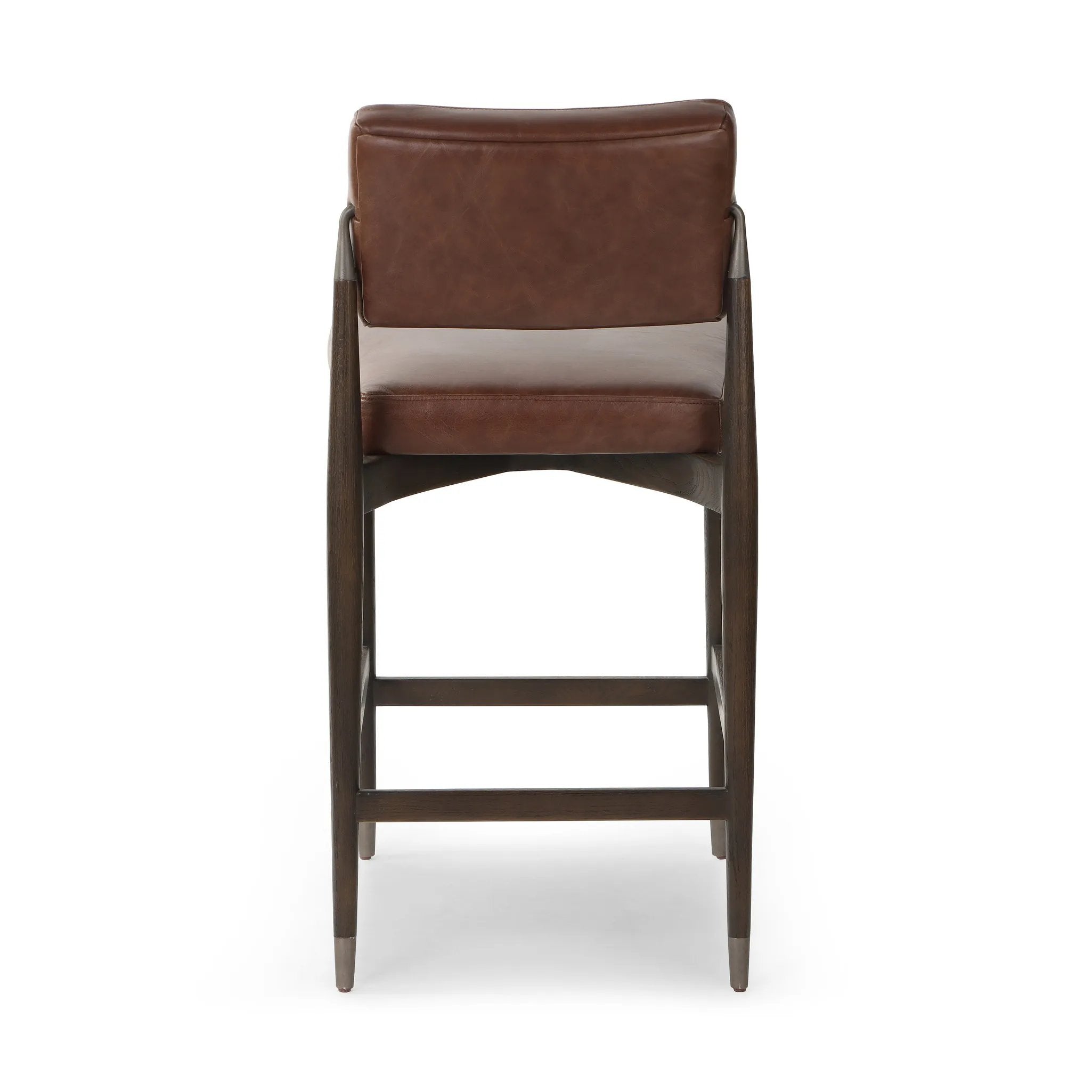 Featuring Anton Havana Brown  Bar + Counter Stool by Four Hands at Amethyst Home. Eighties inspiration gone modern. With iron-dipped caps, tapered legs of solid oak frame this counter stool's seat and back, upholstered in brown top-grain leather. Slim wood stretchers add an airy vibe.BarOverall Dimensions: 20.00"w x 23.75"d x 42.75"hWeight: 18.08 lbsCounterOver. Amethyst Home provides interior design, new home construction design consulting, vintage area rugs, and lighting in the Miami metro area.