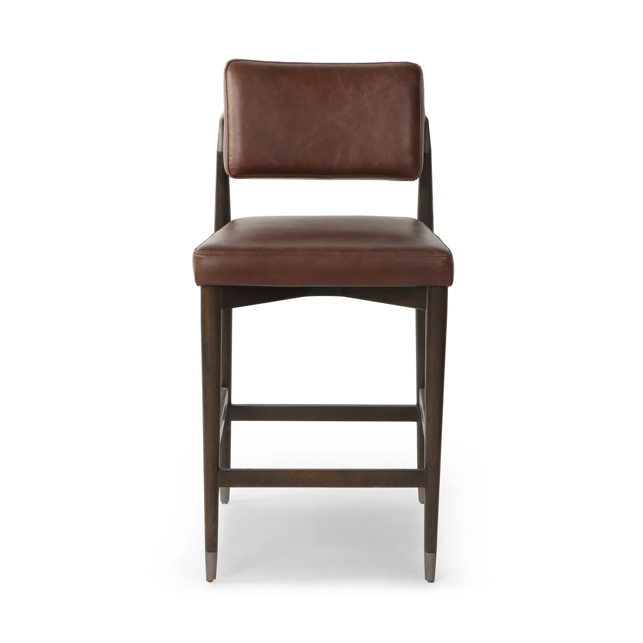 Eighties inspiration gone modern. With iron-dipped caps, tapered legs of solid oak frame this counter stool's seat and back, upholstered in brown top-grain leather. Slim wood stretchers add an airy vibe Amethyst Home provides interior design, new home construction design consulting, vintage area rugs, and lighting in the Winter Garden metro area.