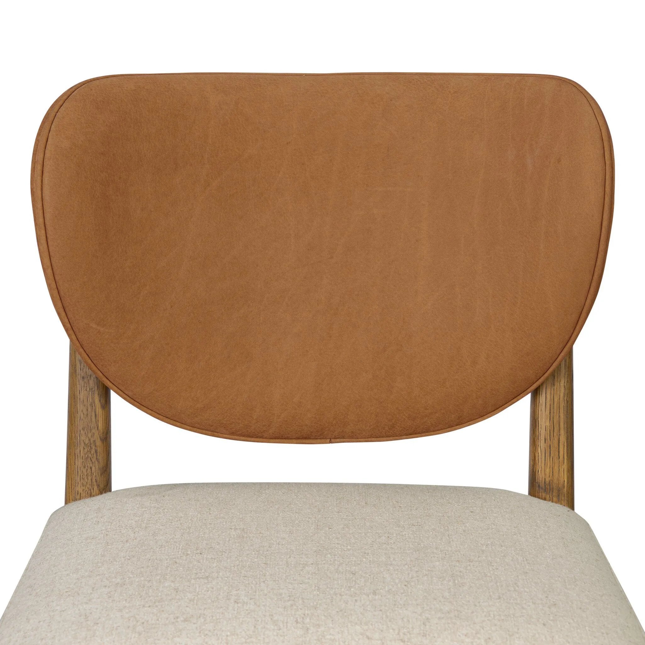 Midcentury meets organic modernism in this mixed-material dining chair. A top-grain leather seat back pairs with a cushioned seat upholstered in performance fabric, with stitch detailing along the seat back. All framed by solid oak finished in a warm amber. Amethyst Home provides interior design, new home construction design consulting, vintage area rugs, and lighting in the Calabasas metro area.