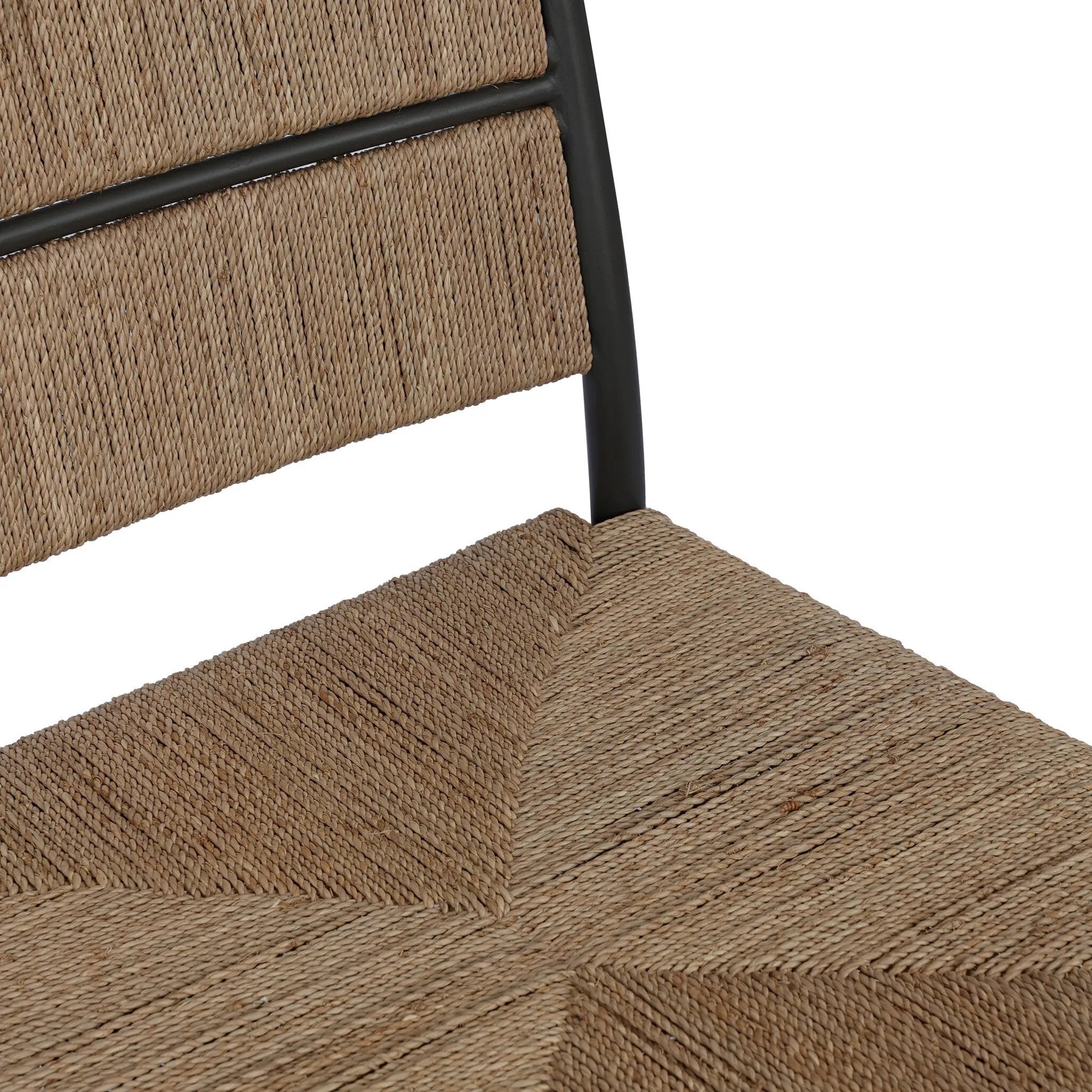 A steel dining chair frame is softened and paired with natural woven fibers. Thin, tapered legs and a tall channeled back cre