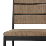 A steel dining chair frame is softened and paired with natural woven fibers. Thin, tapered legs and a tall channeled back cre