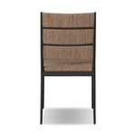 A steel dining chair frame is softened and paired with natural woven fibers. Thin, tapered legs and a tall channeled back cre