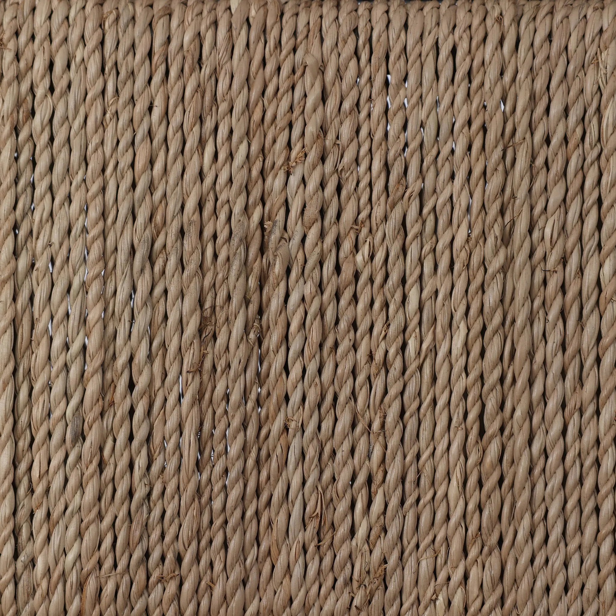 A steel dining chair frame is softened and paired with natural woven fibers. Thin, tapered legs and a tall channeled back cre