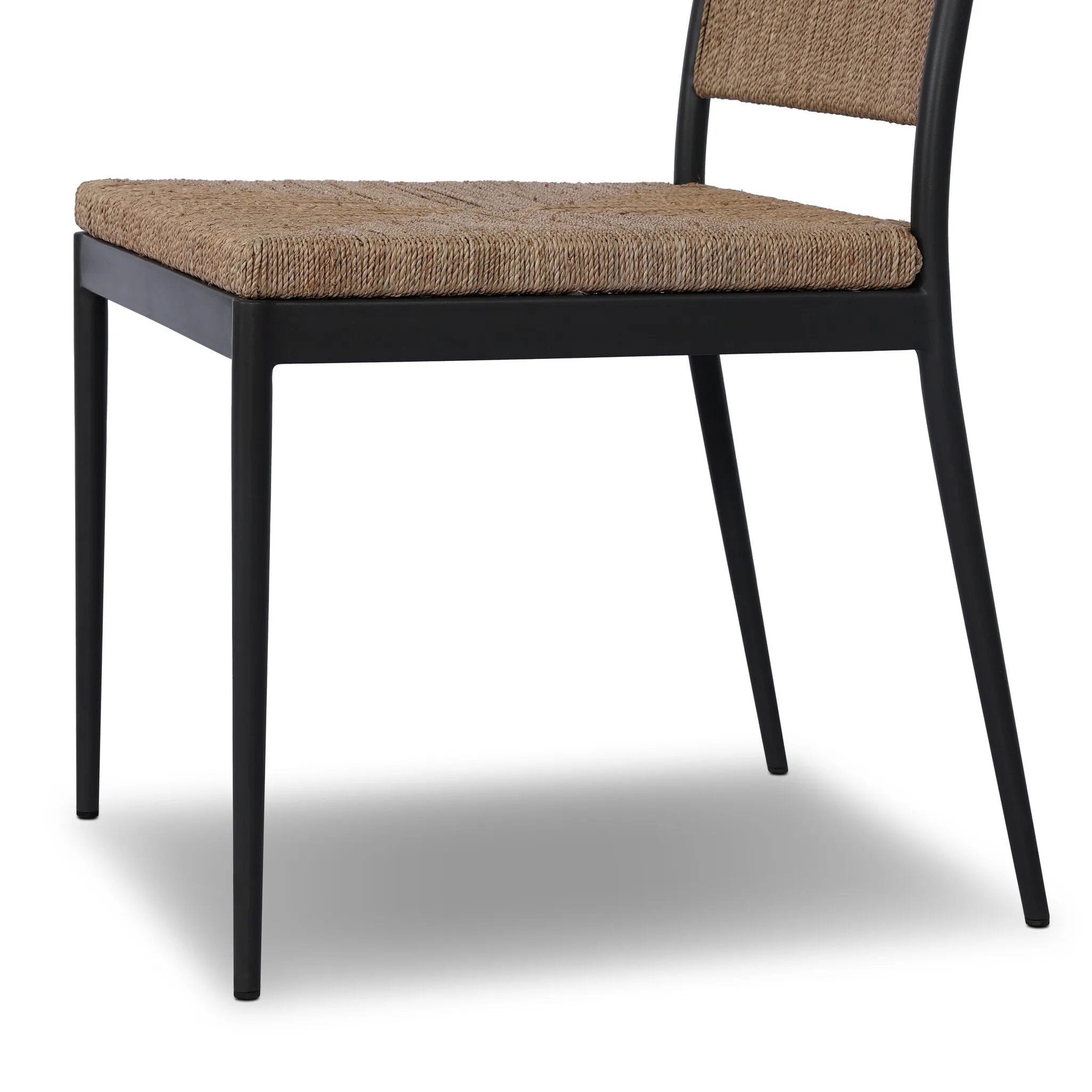 A steel dining chair frame is softened and paired with natural woven fibers. Thin, tapered legs and a tall channeled back cre