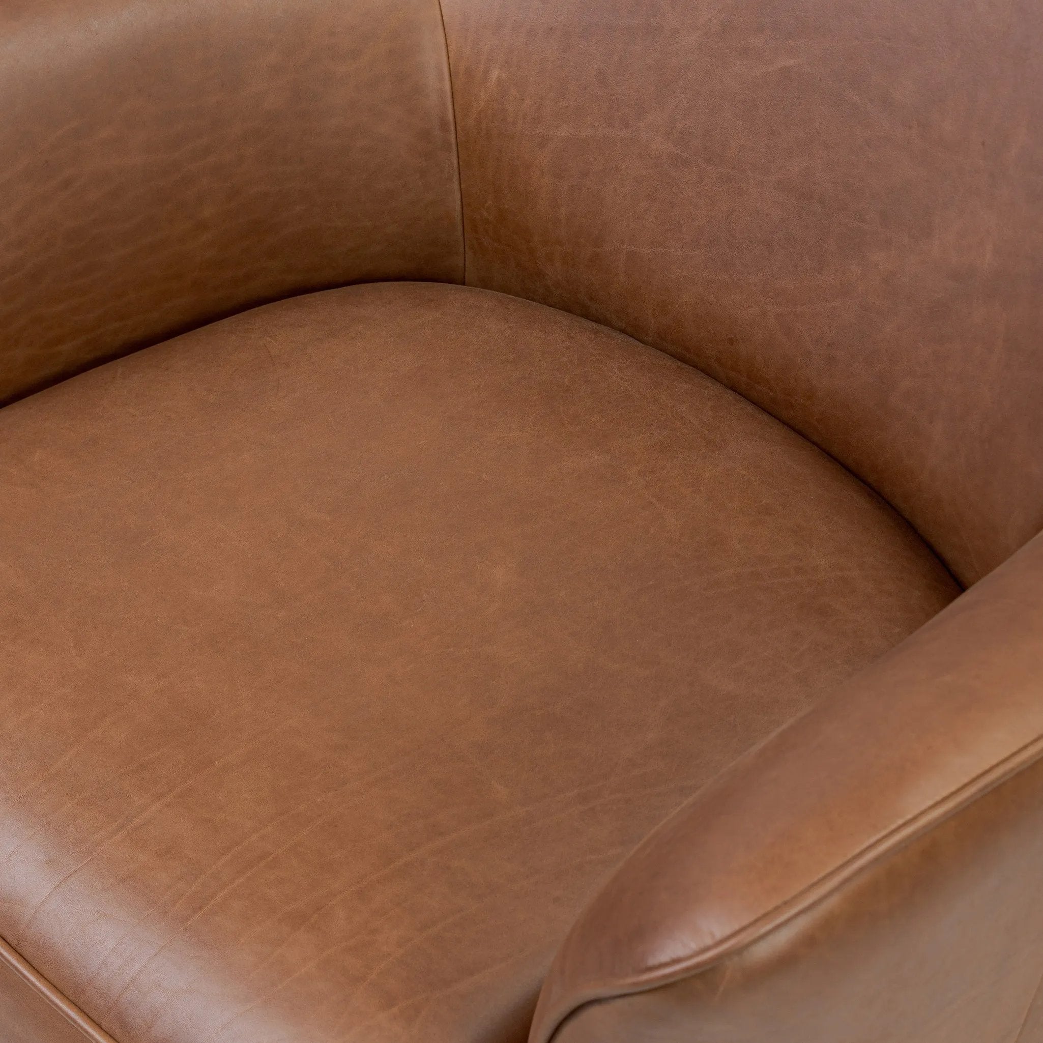 Smooth lines and impeccable tailoring bring a clean, elevated look to this modernized 360 swivel chair. Made from top-grain leather with a rich mahogany finish, flared arms and piping trim reflect the intention behind this timeless design Amethyst Home provides interior design, new home construction design consulting, vintage area rugs, and lighting in the Newport Beach metro area.