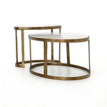 Featuring Calder Polished White Marble Nesting Coffee Table by Four Hands at Amethyst Home. Shapely surfaces, designed to slide together or apart with ease. A raw brass finish lends a lived-in feel to aluminum framing, with one oval-shaped nester topped by polished white marble pairing with a taller, rounded table featuring tempered glass.    Large Table: 3. Amethyst Home provides interior design, new home construction design consulting, vintage area rugs, and lighting in the Calabasas metro area.