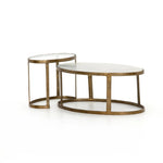 Featuring Calder Polished White Marble Nesting Coffee Table by Four Hands at Amethyst Home. Shapely surfaces, designed to slide together or apart with ease. A raw brass finish lends a lived-in feel to aluminum framing, with one oval-shaped nester topped by polished white marble pairing with a taller, rounded table featuring tempered glass.    Large Table: 38.0. Amethyst Home provides interior design, new home construction design consulting, vintage area rugs, and lighting in the Dallas metro area.