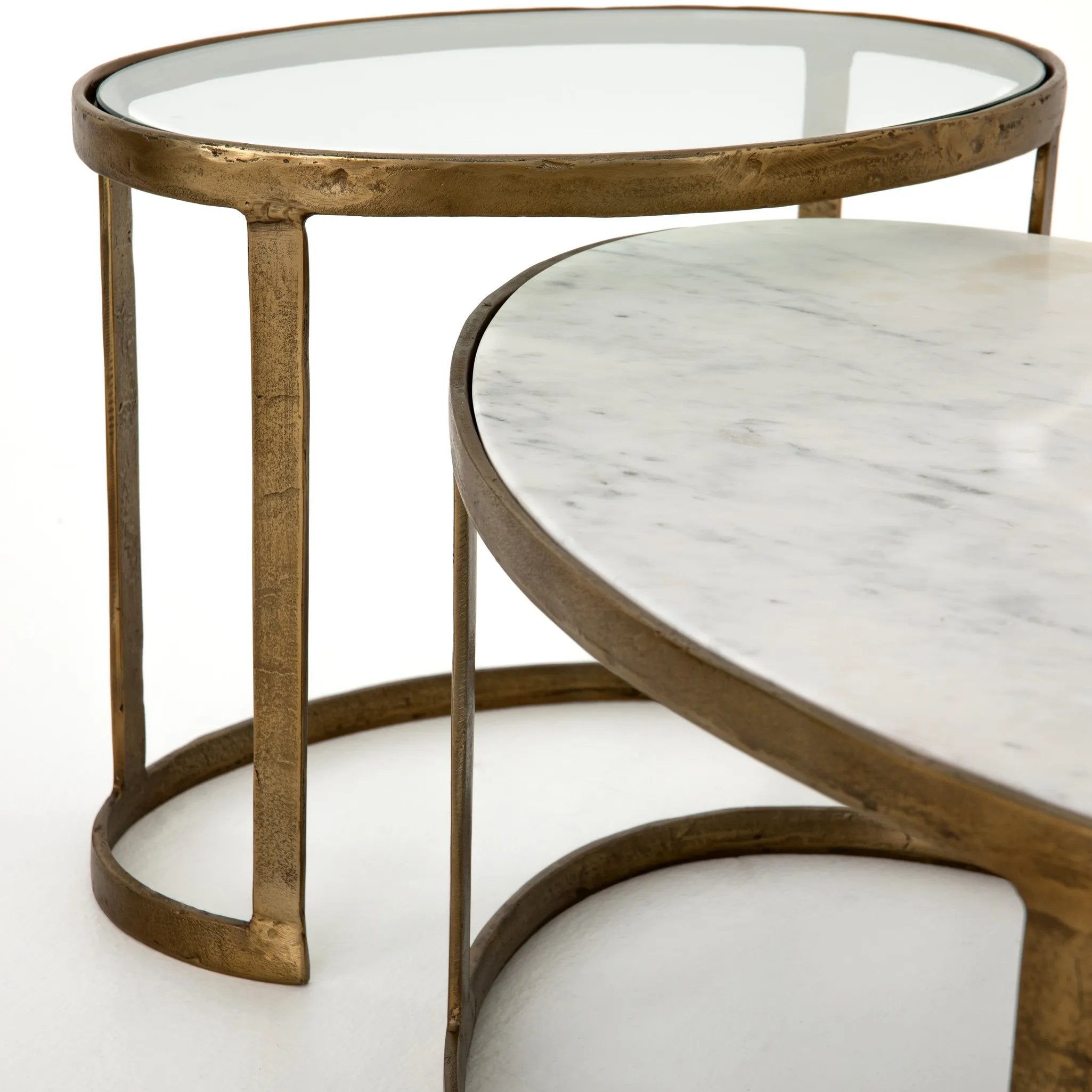 Featuring Calder Polished White Marble Nesting Coffee Table by Four Hands at Amethyst Home. Shapely surfaces, designed to slide together or apart with ease. A raw brass finish lends a lived-in feel to aluminum framing, with one oval-shaped nester topped by polished white marble pairing with a taller, rounded table featuring tempered glass.    Large Table: 3. Amethyst Home provides interior design, new home construction design consulting, vintage area rugs, and lighting in the San Diego metro area.
