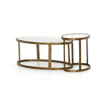 Featuring Calder Polished White Marble Nesting Coffee Table by Four Hands at Amethyst Home. Shapely surfaces, designed to slide together or apart with ease. A raw brass finish lends a lived-in feel to aluminum framing, with one oval-shaped nester topped by polished white marble pairing with a taller, rounded table featuring tempered glass.    Large Tabl. Amethyst Home provides interior design, new home construction design consulting, vintage area rugs, and lighting in the Winter Garden metro area.