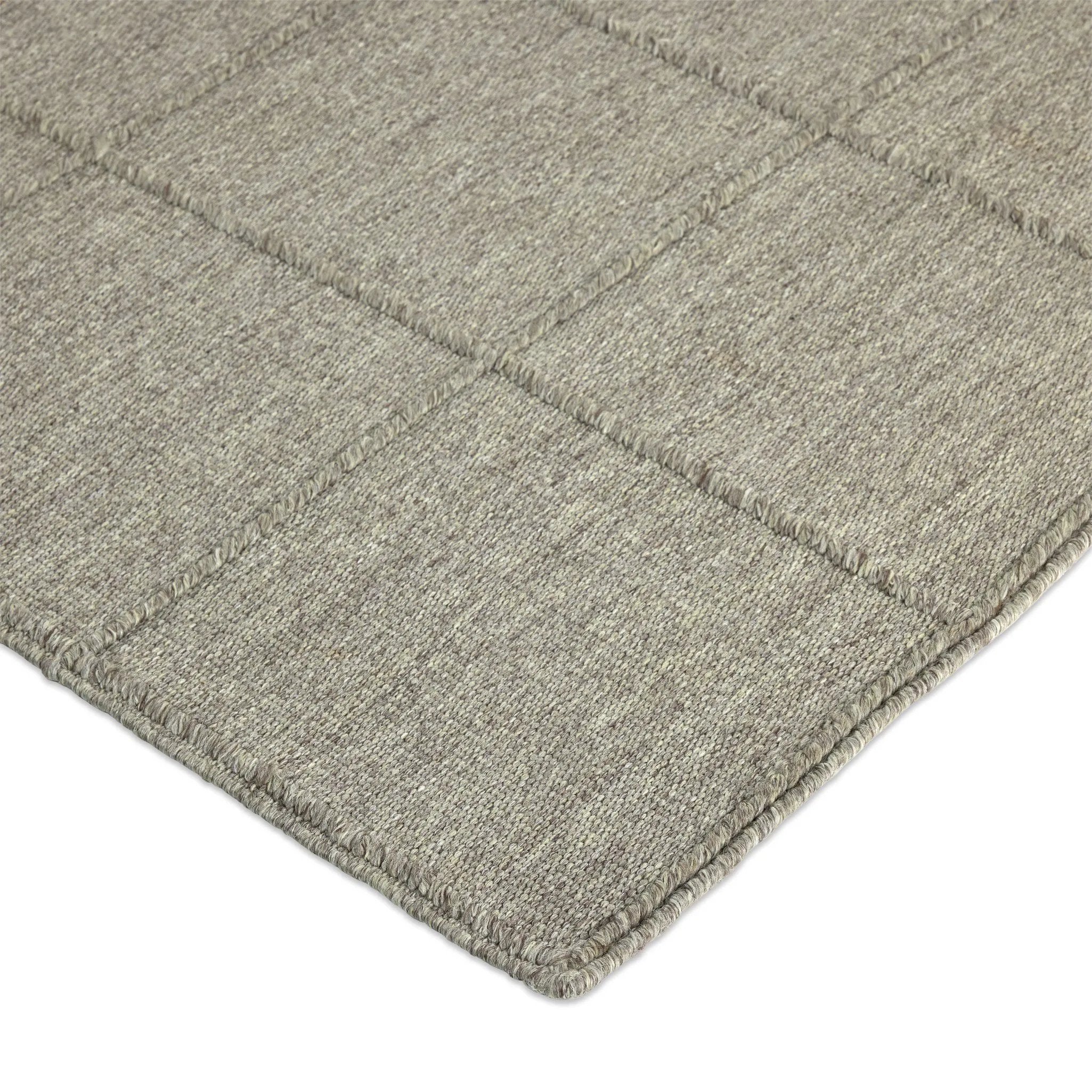 Hand woven in a flat weave grid pattern for the look of an indoor textile, this  silver-hued rug grounds the outdoor lounge with a high-texture look. Slight variation in sizing and imperfect lines due to the handcrafted nature of each piece are to be expected. Store inside during inclement weather and when not in use. Amethyst Home provides interior design, new home construction design consulting, vintage area rugs, and lighting in the Omaha metro area.