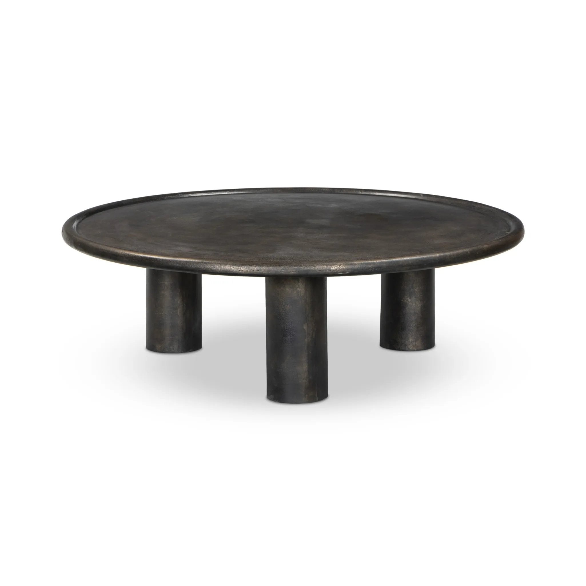 A round, three-legged coffee table of cast aluminum is finished in a beautiful distressed bronze. The result: a luxe take on industrial that moves between spaces and styles with ease Amethyst Home provides interior design, new home construction design consulting, vintage area rugs, and lighting in the Seattle metro area.