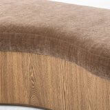 Elevate any room with a curvy statement bench. Made from a kidney-shaped base of toasted ash veneer and a soft, velvety seat Amethyst Home provides interior design, new home construction design consulting, vintage area rugs, and lighting in the Austin metro area.