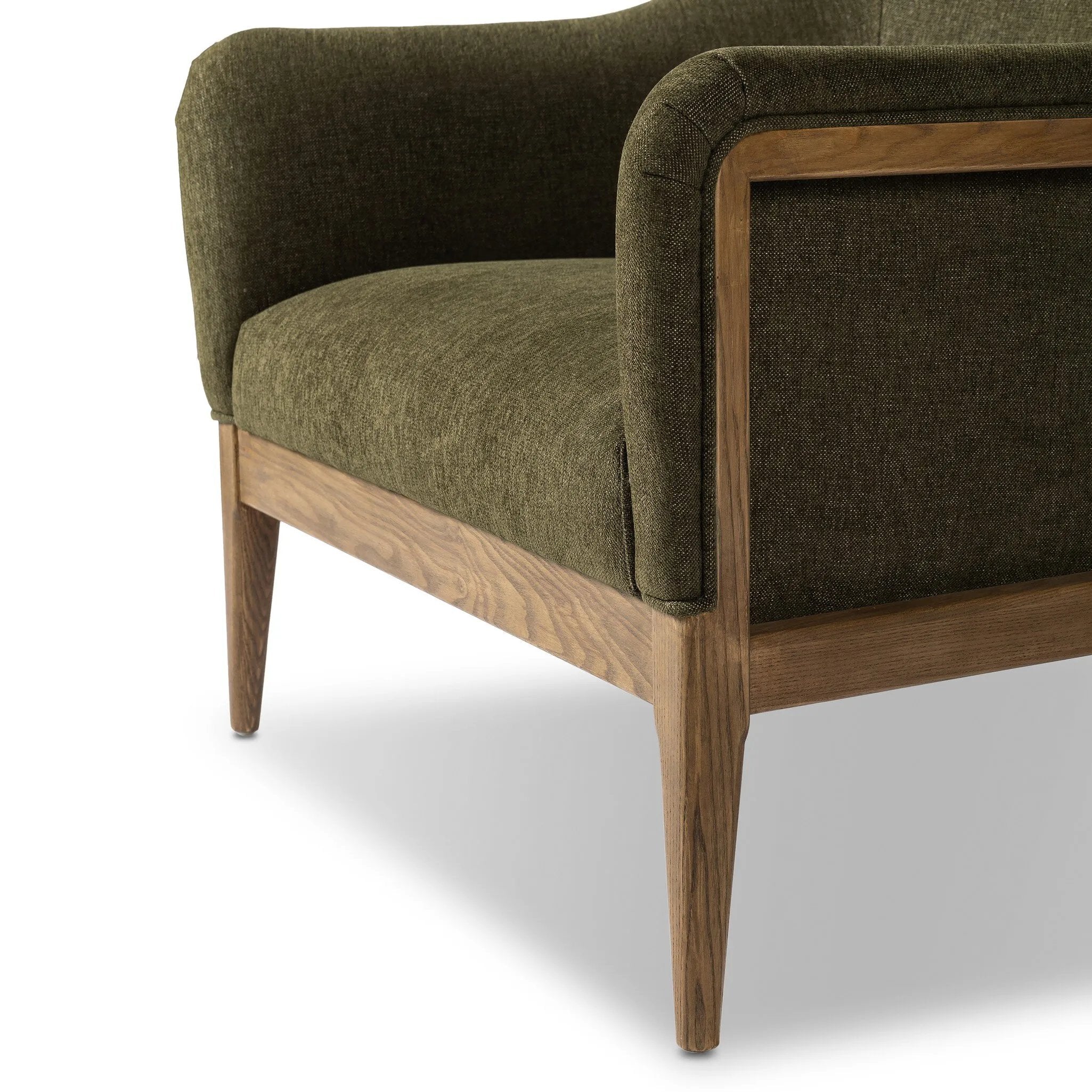 A Swedish Gustavian inspired captain chair gets a modern update with high arms and an exposed frame. The tight cushion in olive fabric paired with buff parawood lends a luxe natural feel Amethyst Home provides interior design, new home construction design consulting, vintage area rugs, and lighting in the Charlotte metro area.