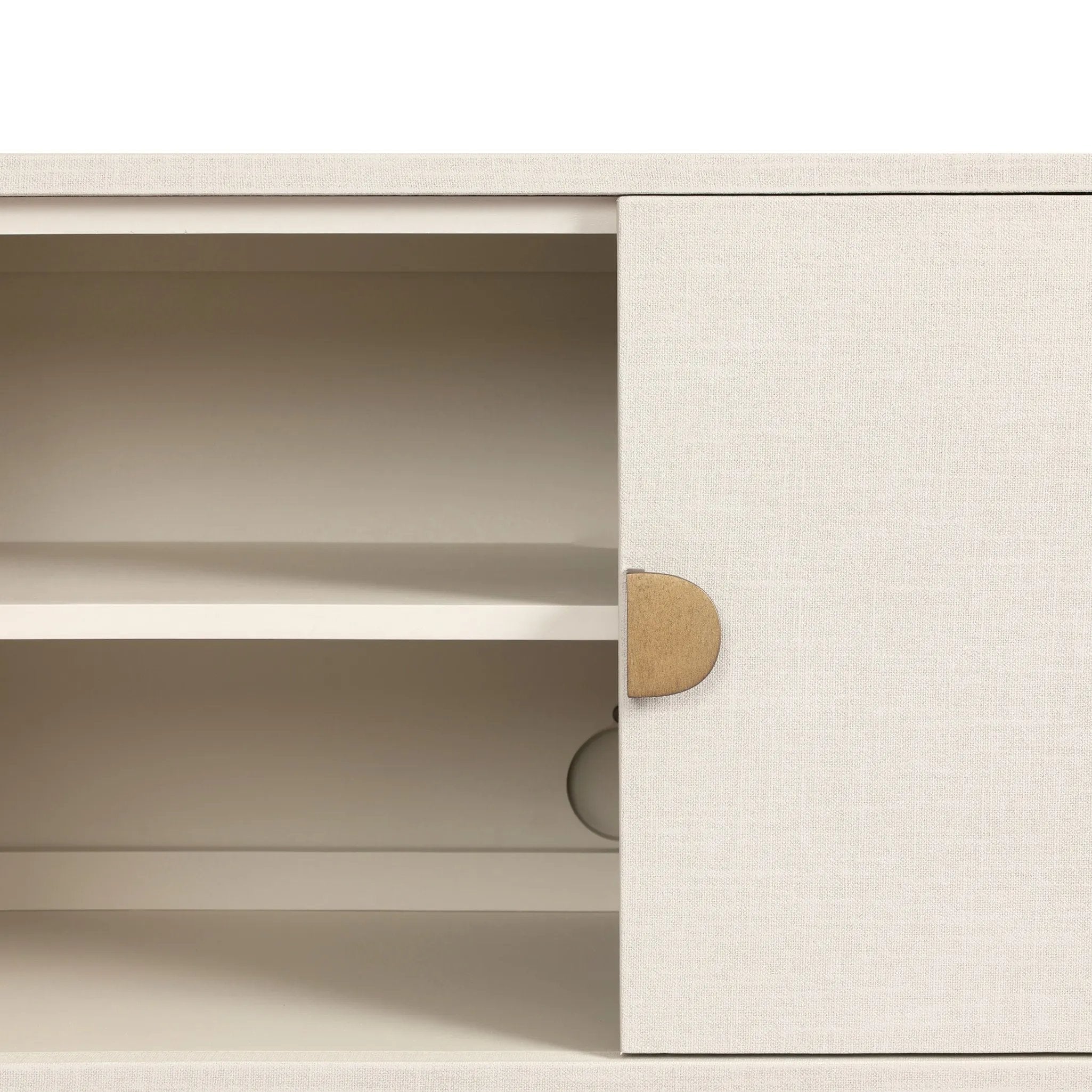 Talk about novelty. Made from painted linen in a light ivory, arched legs soften otherwise clean, modern shaping. Finished in an antique brass, half-moon iron hardware completes this media storage look. Dual rear cutouts for cord management Amethyst Home provides interior design, new home construction design consulting, vintage area rugs, and lighting in the Newport Beach metro area.