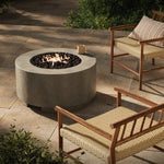 This outdoor fire table is a welcoming centerpiece designed for gathering. Made from glass-reinforced concrete, each piece is naturally finished with deep tones of pewter and dark grey. The monolithic shape is completed with lavastones in the center, bringing together a bold, monochromatic look. Amethyst Home provides interior design, new home construction design consulting, vintage area rugs, and lighting in the Monterey metro area.