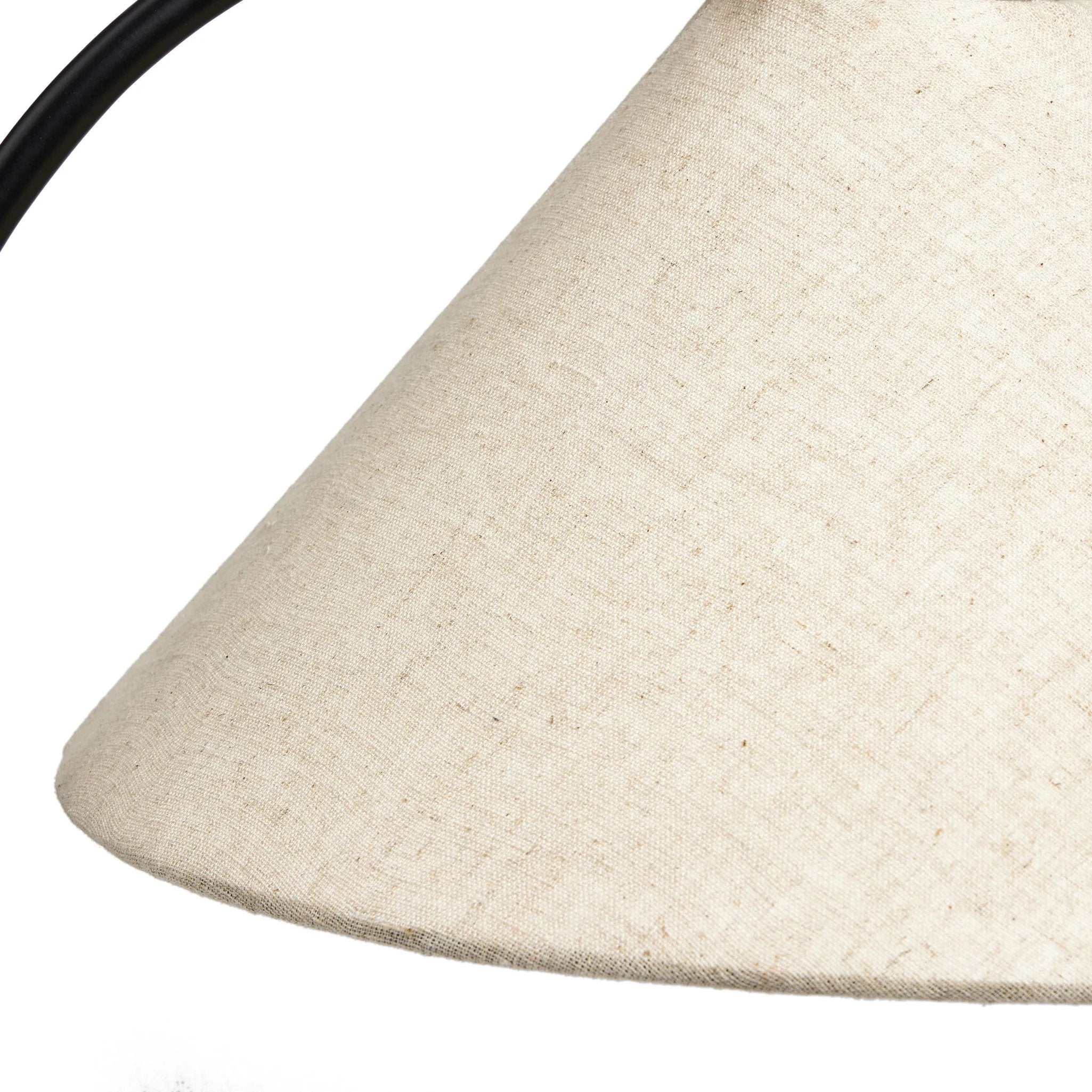 A dramatically curved silhouette and tripod base of matte black metal pair with a flax linen shade for a shapely, minimalist feel Amethyst Home provides interior design, new home construction design consulting, vintage area rugs, and lighting in the Des Moines metro area.