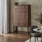 Made from solid oak and finished in a rich cocoa, tall cabinetry is carved with a unique grid-like pattern, for an organic look and textural touch. Interior shelving made from solid mango brings bonus storage to any room. Subtle variations in natural wood graining to be expected Amethyst Home provides interior design, new home construction design consulting, vintage area rugs, and lighting in the Des Moines metro area.
