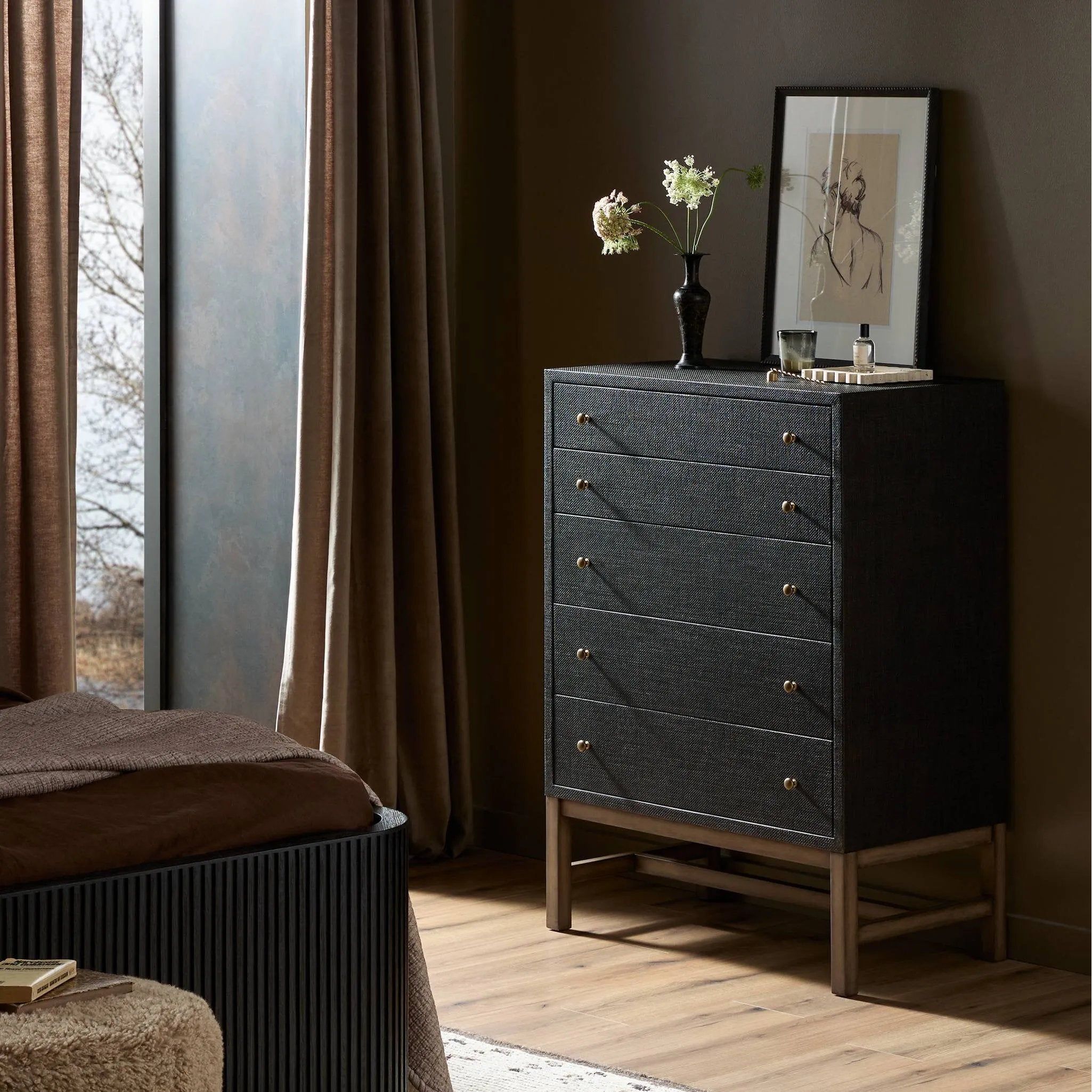A woven black raffia dresser offers a texture-driven take on bedroom storage. Antique brass-finished hardware adds a touch of vintage detailing, all grounded by a solid mahogany base Amethyst Home provides interior design, new home construction design consulting, vintage area rugs, and lighting in the Austin metro area.