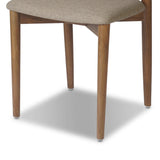 Bring a mixed material moment to your dining space with a Scandinavian-inspired seating style. Solid parawood forms a beautifully curved frame for a slim-profile seat upholstered in taupe high-performance fabric. On the back panel, a thin iron inlay elevates the look with a detail-driven finishing touch. Amethyst Home provides interior design, new home construction design consulting, vintage area rugs, and lighting in the Dallas metro area.