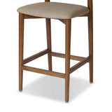 Inspired by simple Scandinavian styling, a tan-finished parawood stool's slit-back metal inlay adds a decorative touch. Easy curves from bent wood give a smooth silhouette. Sized for the counter and upholstered with a thin seat cushion in linen-cotton taupe Amethyst Home provides interior design, new home construction design consulting, vintage area rugs, and lighting in the Calabasas metro area.