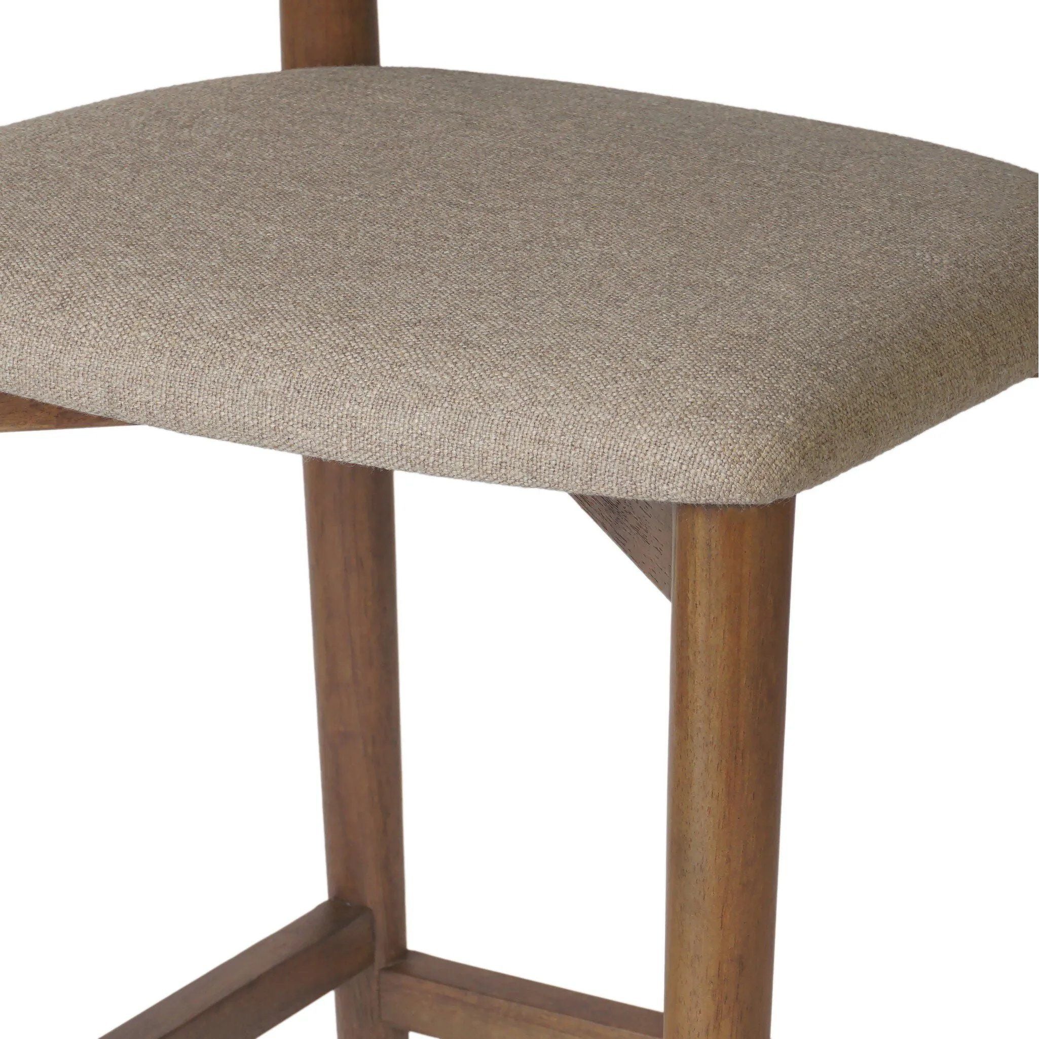Inspired by simple Scandinavian styling, a tan-finished parawood stool's slit-back metal inlay adds a decorative touch. Easy curves from bent wood give a smooth silhouette. Sized for the counter and upholstered with a thin seat cushion in linen-cotton taupe Amethyst Home provides interior design, new home construction design consulting, vintage area rugs, and lighting in the Seattle metro area.