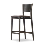 Inspired by simple Scandinavian styling, a dark-finished parawood stool's slit-back metal inlay adds a decorative touch. Easy curves from bent wood give a smooth silhouette. Sized for the counter and upholstered with a thin seat cushion upholstered in black performance fabric, perfect for dining or entertaining. Amethyst Home provides interior design, new home construction design consulting, vintage area rugs, and lighting in the Nashville metro area.