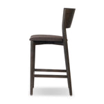 Inspired by simple Scandinavian styling, a dark-finished parawood stool's slit-back metal inlay adds a decorative touch. Easy curves from bent wood give a smooth silhouette. Sized for the counter and upholstered with a thin seat cushion upholstered in black performance fabric, perfect for dining or entertaining. Amethyst Home provides interior design, new home construction design consulting, vintage area rugs, and lighting in the Tampa metro area.