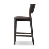 Inspired by simple Scandinavian styling, a dark-finished parawood stool's slit-back metal inlay adds a decorative touch. Easy curves from bent wood give a smooth silhouette. Sized for the counter and upholstered with a thin seat cushion upholstered in black performance fabric, perfect for dining or entertaining. Amethyst Home provides interior design, new home construction design consulting, vintage area rugs, and lighting in the Tampa metro area.