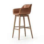 A midcentury-inspired counter stool gets refreshed with a modern memory swivel and chestnut top-grain leather. Slim, tapered oak legs balance a curved seat Amethyst Home provides interior design, new home construction design consulting, vintage area rugs, and lighting in the Boston metro area.
