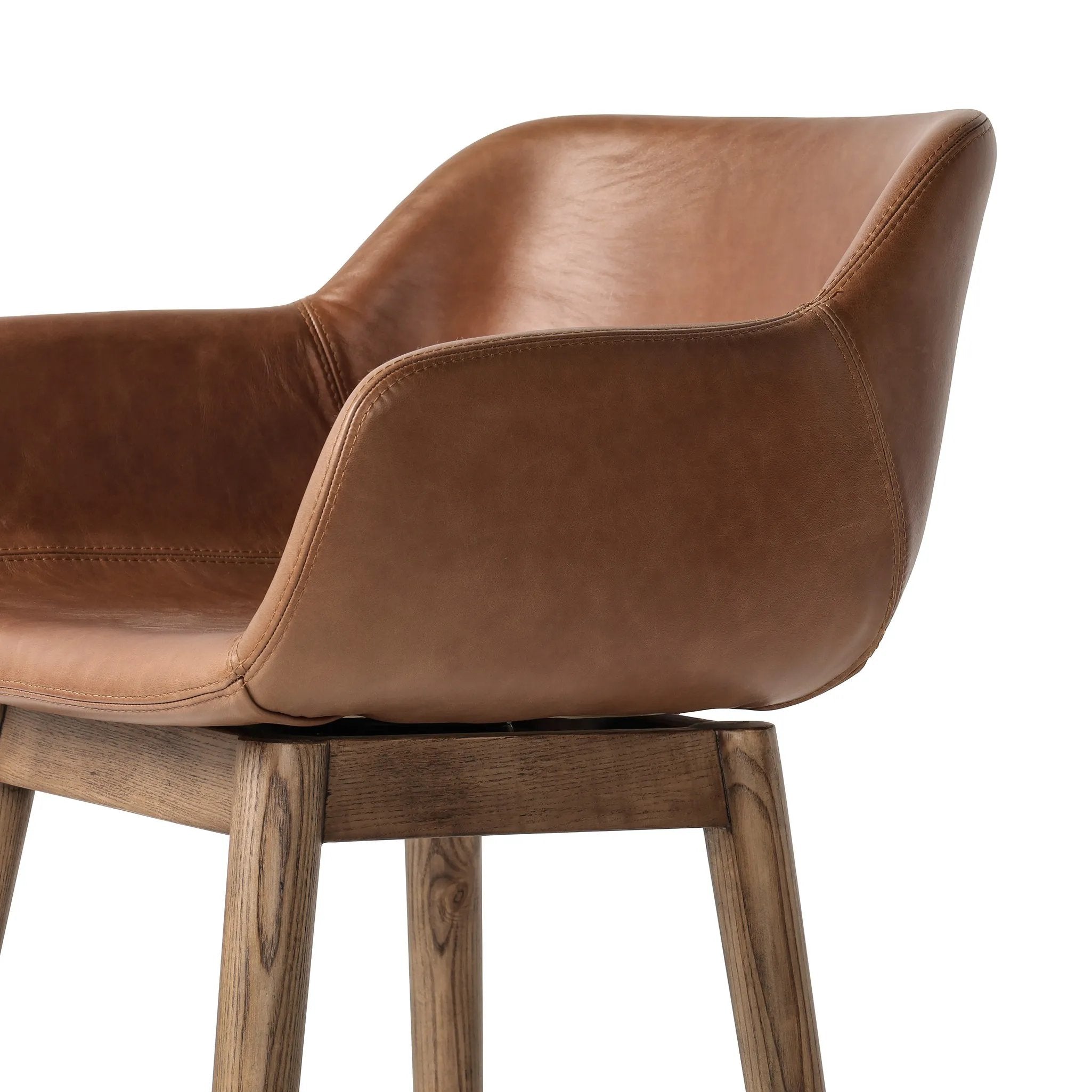 A midcentury-inspired counter stool gets refreshed with a modern memory swivel and chestnut top-grain leather. Slim, tapered oak legs balance a curved seat Amethyst Home provides interior design, new home construction design consulting, vintage area rugs, and lighting in the Calabasas metro area.