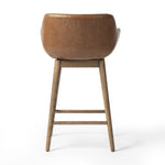 A midcentury-inspired counter stool gets refreshed with a modern memory swivel and chestnut top-grain leather. Slim, tapered oak legs balance a curved seat Amethyst Home provides interior design, new home construction design consulting, vintage area rugs, and lighting in the Dallas metro area.