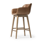 A midcentury-inspired counter stool gets refreshed with a modern memory swivel and chestnut top-grain leather. Slim, tapered oak legs balance a curved seat Amethyst Home provides interior design, new home construction design consulting, vintage area rugs, and lighting in the Miami metro area.