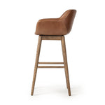 A midcentury-inspired counter stool gets refreshed with a modern memory swivel and chestnut top-grain leather. Slim, tapered oak legs balance a curved seat Amethyst Home provides interior design, new home construction design consulting, vintage area rugs, and lighting in the Washington metro area.