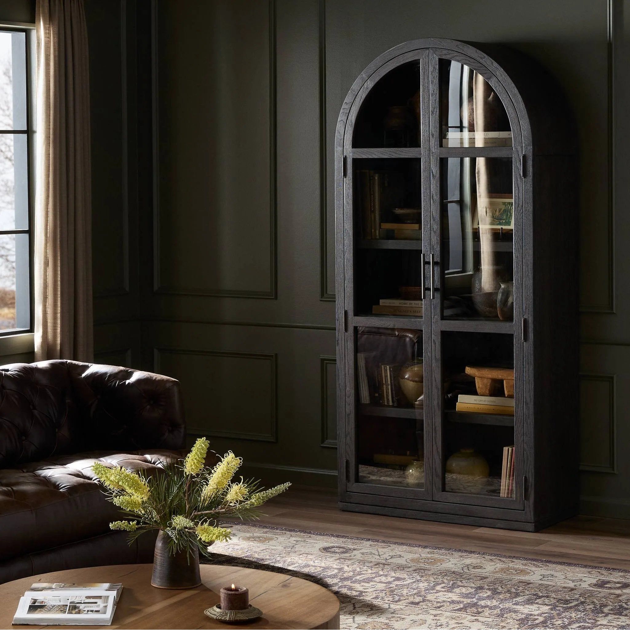Featuring Hepburn Dark Anthracite Oak Veneer Cabinet by Four Hands at Amethyst Home. Beautifully arched with a flush plinth base, a versatile oak cabinet features a dark, rich finish. With generous interior shelving, a tempered glass front allows you to showcase favorite books and treasures — letting anyone who enters your space know exactly who you are. Overa. Amethyst Home provides interior design, new home construction design consulting, vintage area rugs, and lighting in the Dallas metro area.