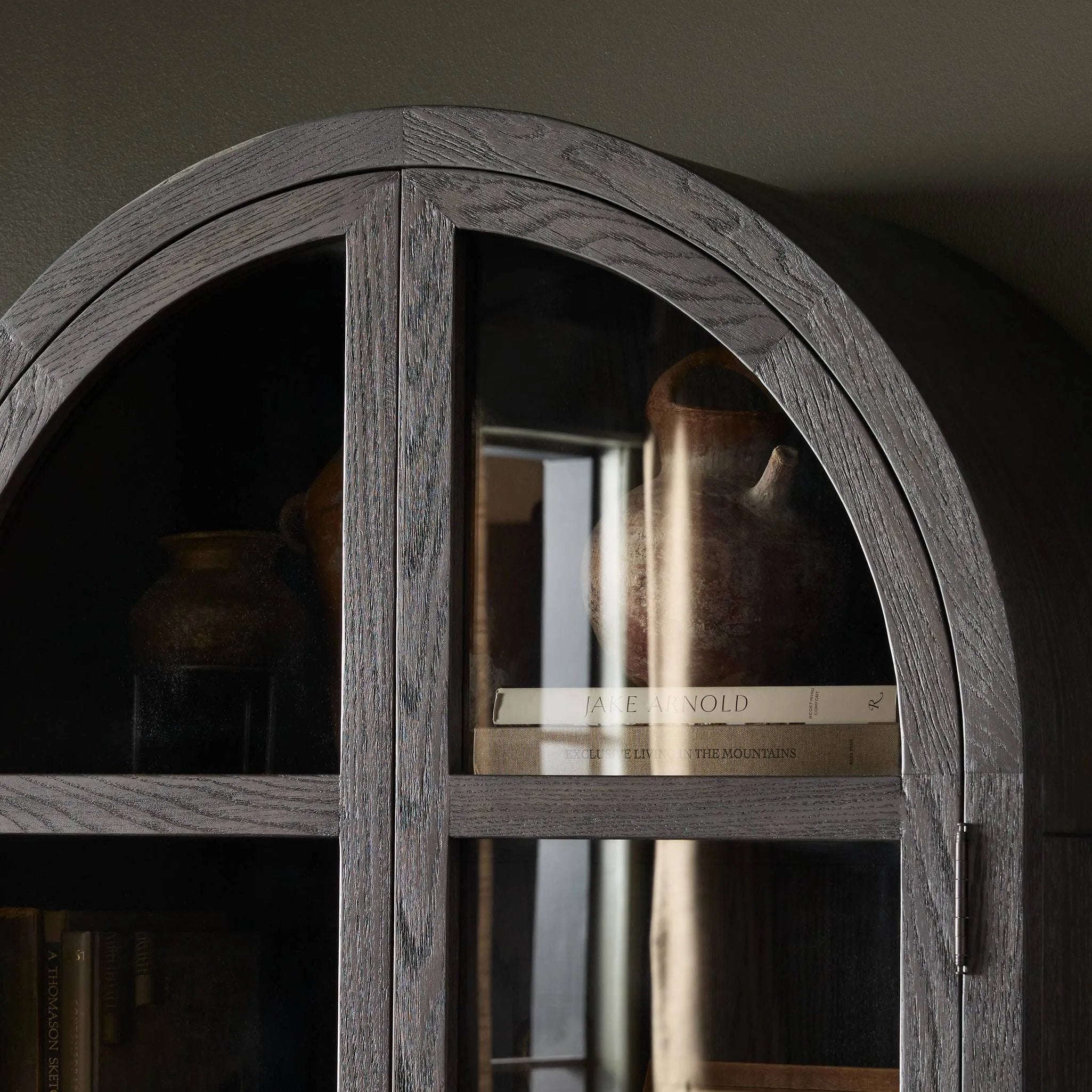 Featuring Hepburn Dark Anthracite Oak Veneer Cabinet by Four Hands at Amethyst Home. Beautifully arched with a flush plinth base, a versatile oak cabinet features a dark, rich finish. With generous interior shelving, a tempered glass front allows you to showcase favorite books and treasures — letting anyone who enters your space know exactly who you are. O. Amethyst Home provides interior design, new home construction design consulting, vintage area rugs, and lighting in the Washington metro area.