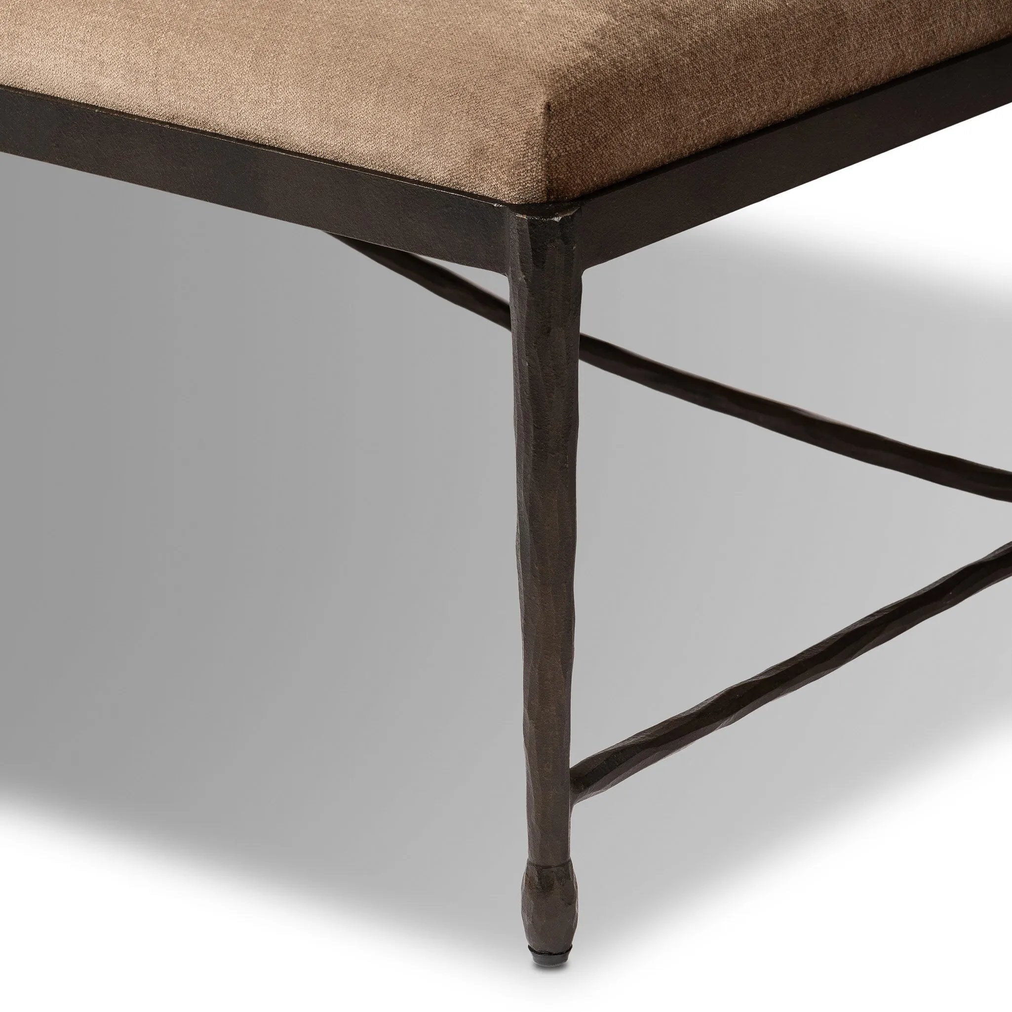 This French Industrialist-inspired cocktail ottoman features a curved stretcher base of bronzed hammered iron and a velvety seat in a versatile earth tone. Style with a sofa or sectional to create an extra surface in your living space, or for bonus seating. Amethyst Home provides interior design, new home construction design consulting, vintage area rugs, and lighting in the Salt Lake City metro area.