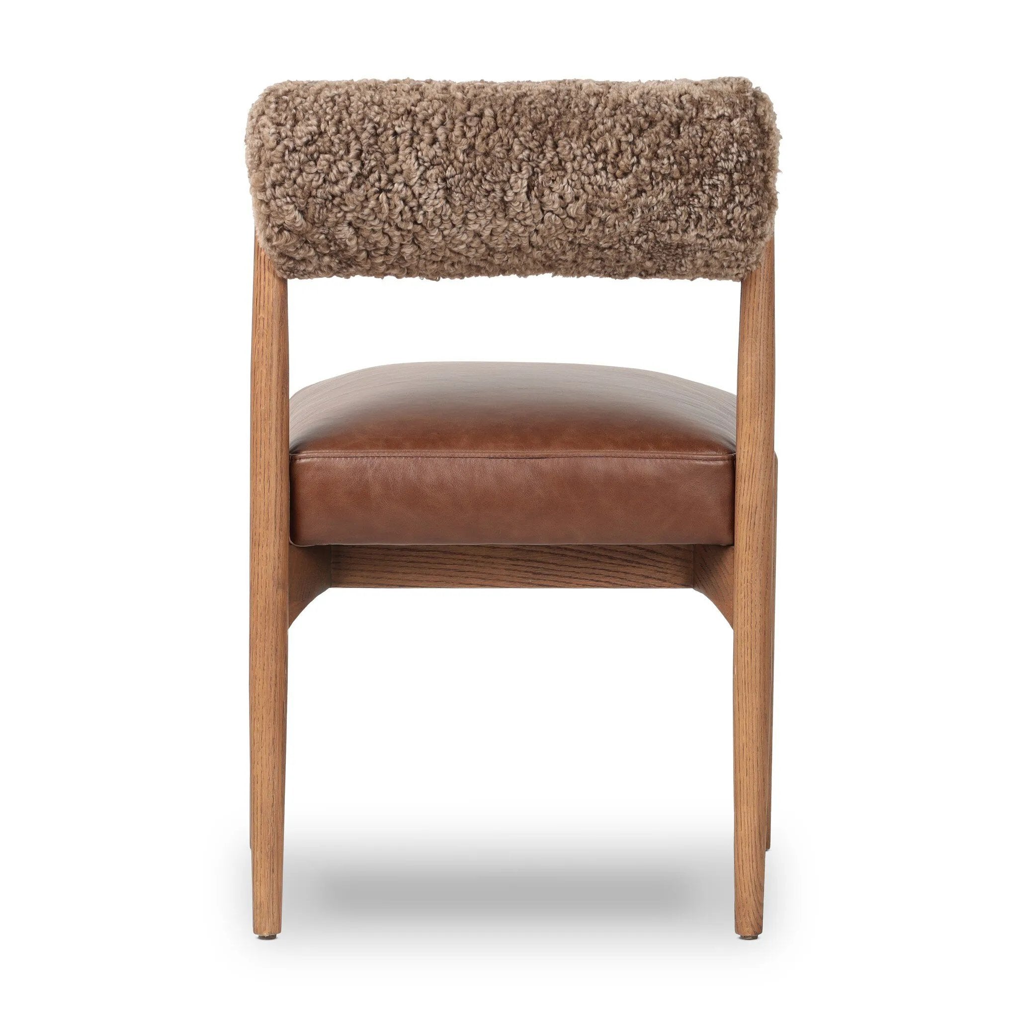 Featuring Jazelle Taupe Shearling Dining Chair by Four Hands at Amethyst Home. The armless dining chair gets a playful update with mixed materials and a bolstered cylinder seat back. Inspired by midcentury and Seventies styling and made from solid oak, top-grain leather  and soft shearling to elevate your bar, kitchen or dining space. Overall Dimensions: 22.25. Amethyst Home provides interior design, new home construction design consulting, vintage area rugs, and lighting in the Dallas metro area.