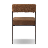 The armless dining chair gets a playful update with a bolstered cylinder seat back. Made from soft shearling and hammered met