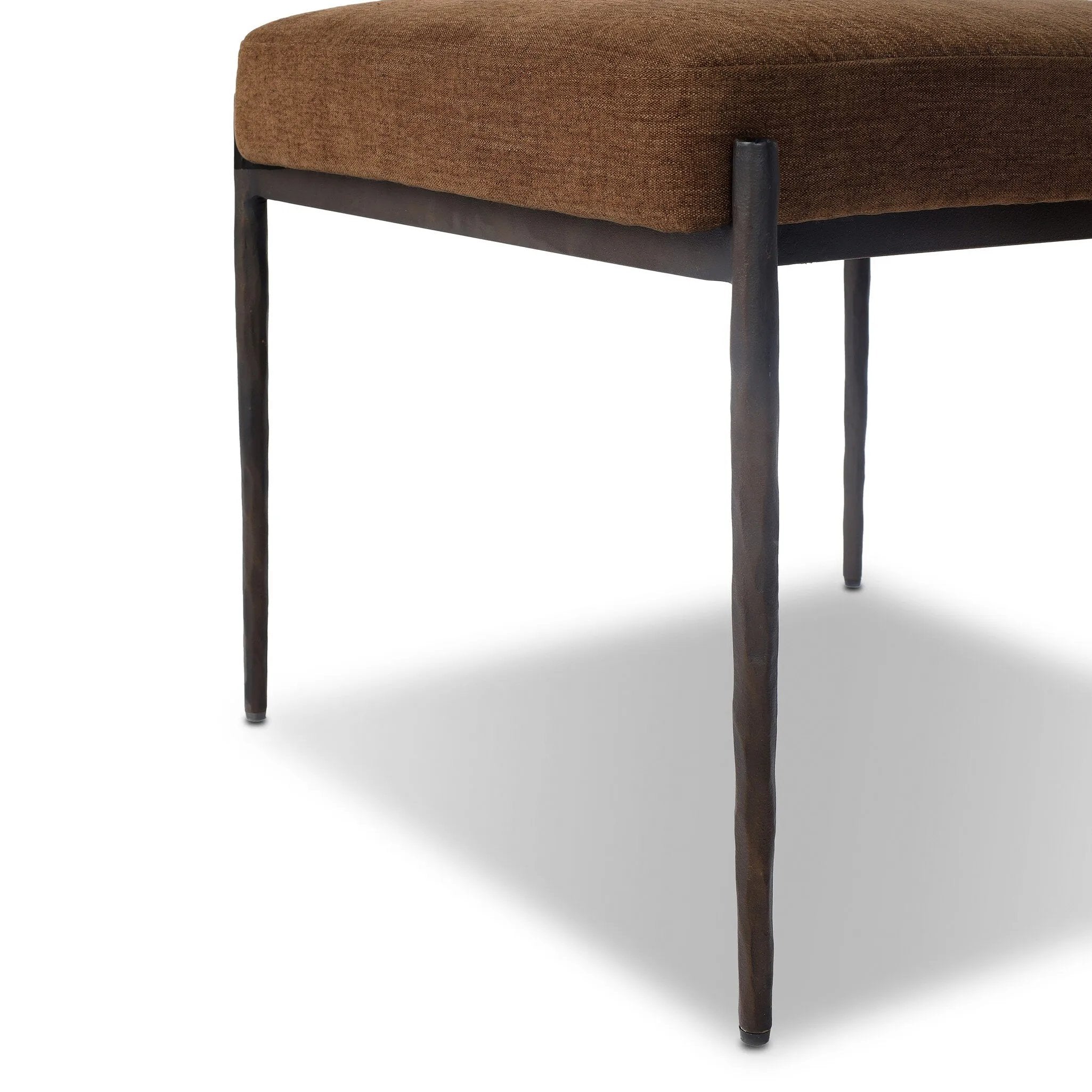 The armless dining chair gets a playful update with a bolstered cylinder seat back. Made from soft shearling and hammered met