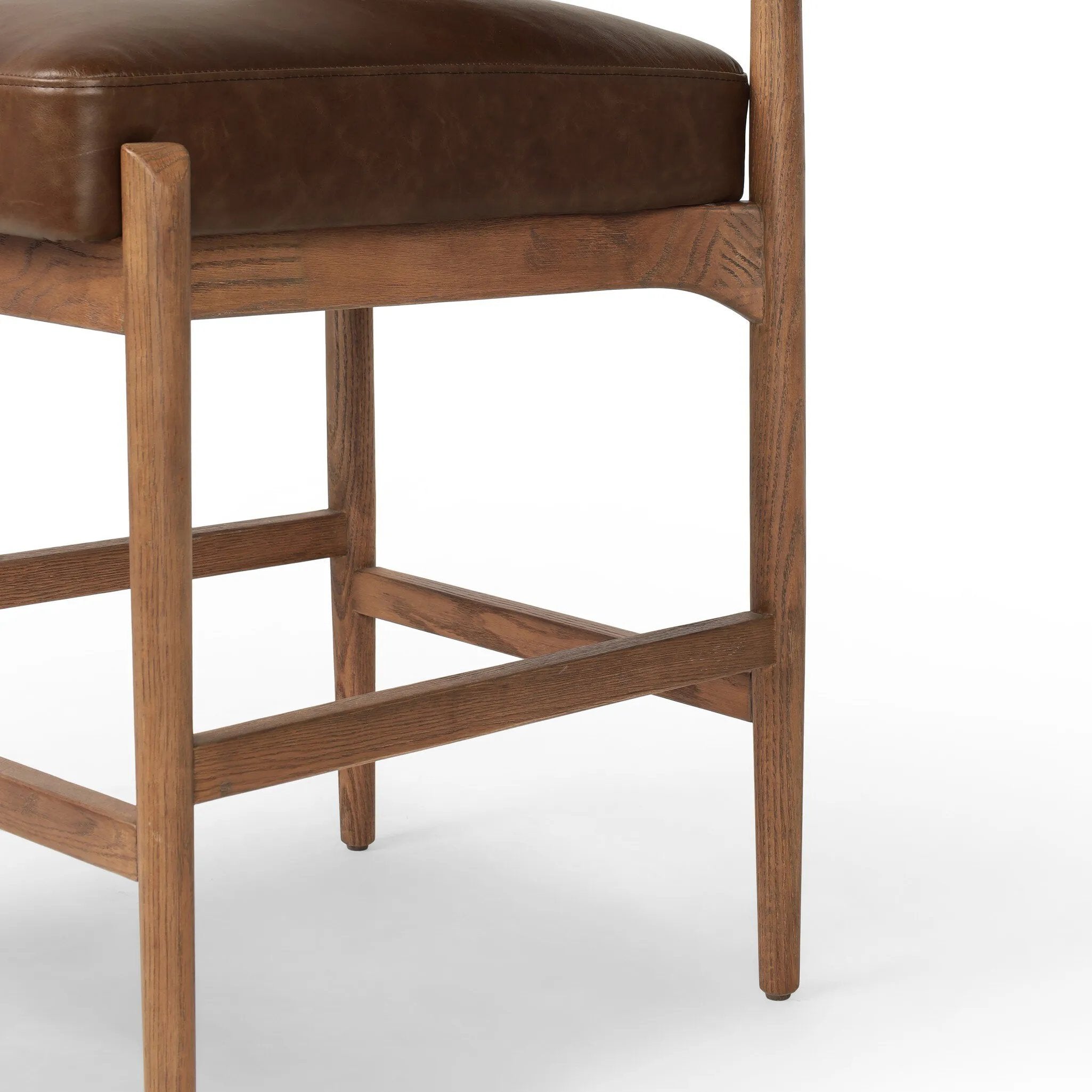 The classic counter stool gets a playful update with a bolstered cylinder seat back. Made from top-grain leather, velvet-like upholstery and warm-finished oak to elevate your bar, kitchen or dining space Amethyst Home provides interior design, new home construction design consulting, vintage area rugs, and lighting in the Houston metro area.
