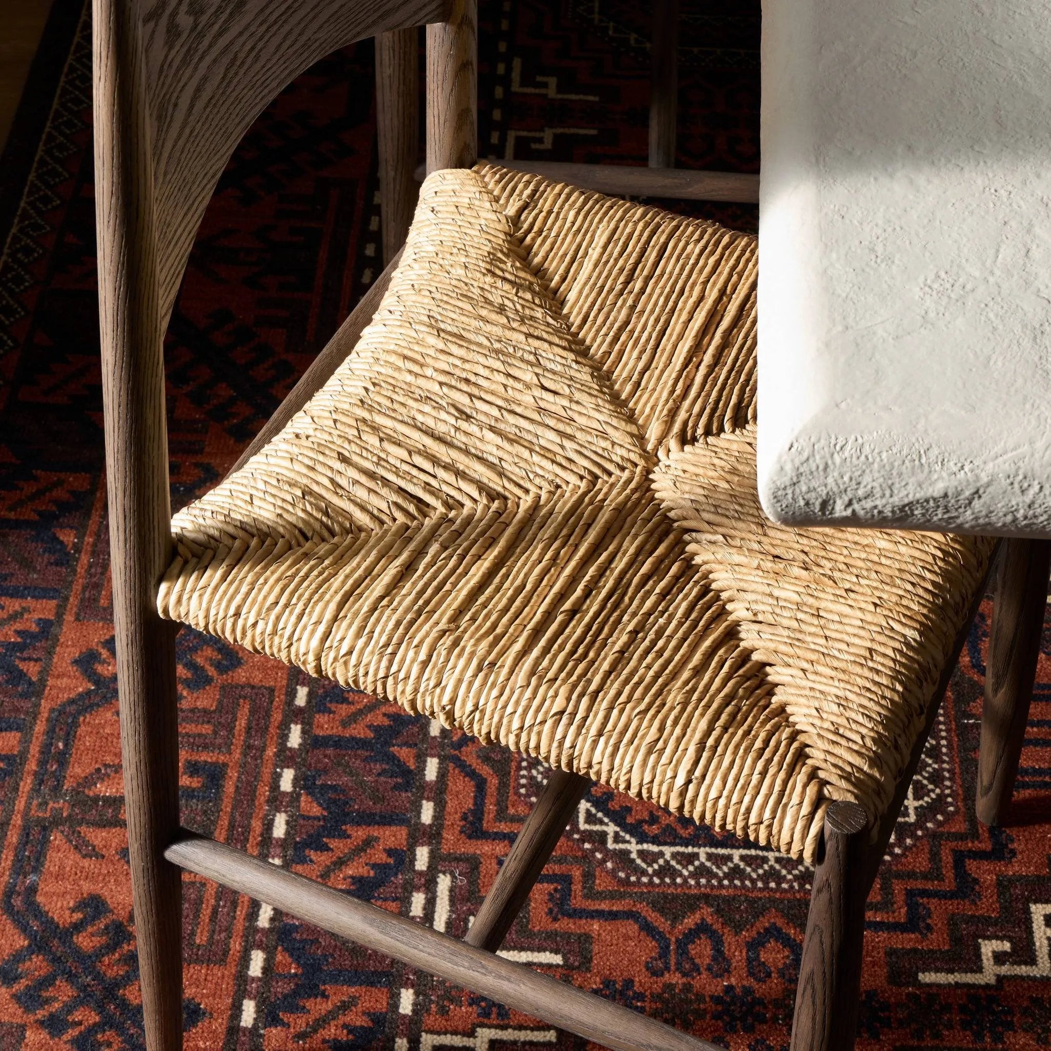 A seamless addition to your dining collection, a slim-profile dining chair pairs a woven banana leaf seat with a solid oak frame featuring a bentwood back Amethyst Home provides interior design, new home construction design consulting, vintage area rugs, and lighting in the Kansas City metro area.