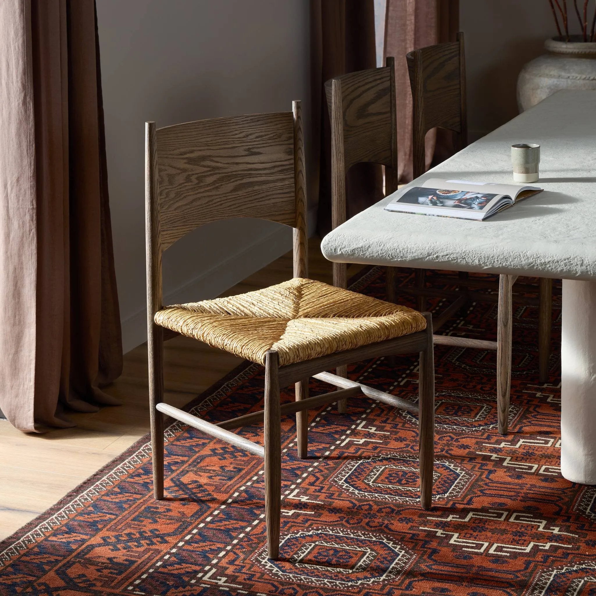 A seamless addition to your dining collection, a slim-profile dining chair pairs a woven banana leaf seat with a solid oak frame featuring a bentwood back Amethyst Home provides interior design, new home construction design consulting, vintage area rugs, and lighting in the Winter Garden metro area.