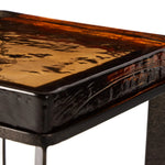 An airy, angular base of charcoal-burnished iron supports a squared tabletop of amber cast glass, perfectly sized to keep your drink or book within reach Amethyst Home provides interior design, new home construction design consulting, vintage area rugs, and lighting in the Austin metro area.