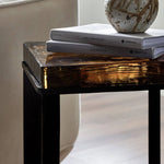 An airy, angular base of charcoal-burnished iron supports a squared tabletop of amber cast glass, perfectly sized to keep your drink or book within reach Amethyst Home provides interior design, new home construction design consulting, vintage area rugs, and lighting in the Kansas City metro area.