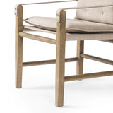 Inspired by a vintage safari-style frame, this dining chair is defined by the fluid strap arms. Semi-attached cushions in taupe performance fabric, finished with button tufting details. Framed out by warm parawood. Amethyst Home provides interior design, new home construction design consulting, vintage area rugs, and lighting in the Newport Beach metro area.