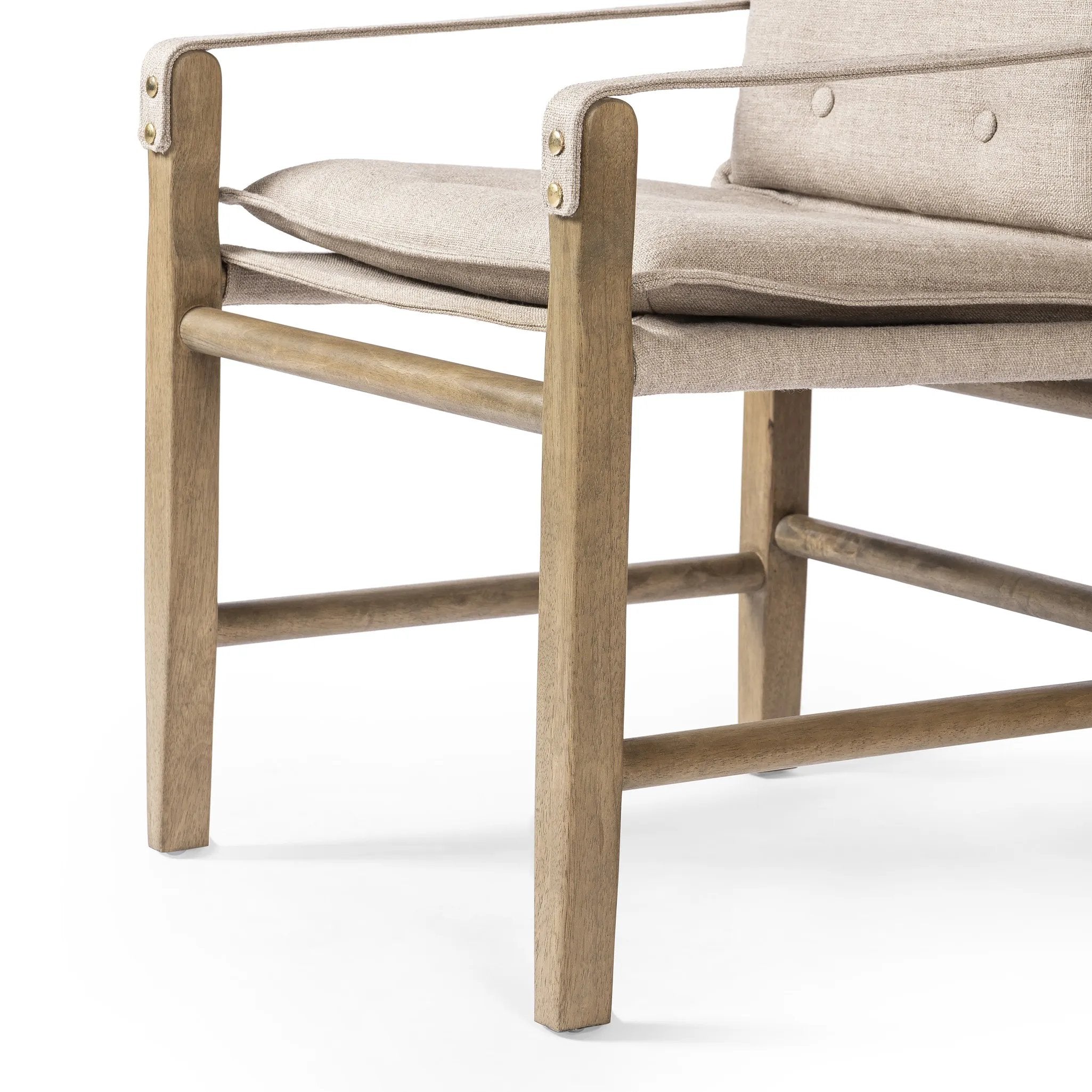 Inspired by a vintage safari-style frame, this dining chair is defined by the fluid strap arms. Semi-attached cushions in taupe performance fabric, finished with button tufting details. Framed out by warm parawood. Amethyst Home provides interior design, new home construction design consulting, vintage area rugs, and lighting in the Newport Beach metro area.